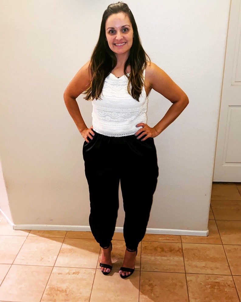 The founder wearing her finished black pants and a white lace top